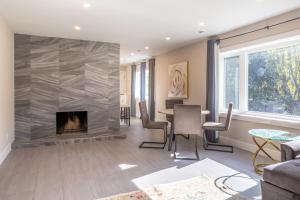 ロンドンにある5 Bedroom Luxury Retreat with Hot Tub and Sauna, Prime Location and More!の暖炉とテーブルと椅子のあるリビングルーム