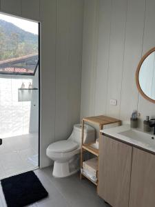 a bathroom with a toilet and a tub and a sink at Cabaña Valle del Cocora in Salento +30 photos