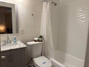 a bathroom with a toilet and a tub and a sink at New comfortable and youthful sport in Fort Lauderdale