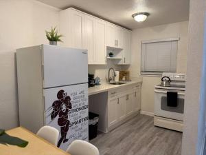 a kitchen with white cabinets and a white refrigerator at New comfortable and youthful sport in Fort Lauderdale