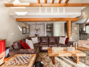 a living room with a leather couch and chessboard at Saddle Ridge F5 home in Big Sky