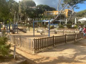 a park with a wooden fence and a playground at Canyelles BBQ Apartment in Lloret de Mar