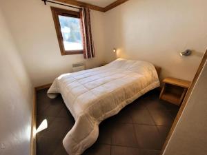 Un dormitorio con una cama en una habitación con ventana. en Résidence Le Criterium - Résidence Le Critérium 3 Chalet B Appartement 2 MAE-4511, en Lanslebourg-Mont-Cenis