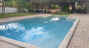 a swimming pool with blue water in a yard at Achab chalets in Usakos