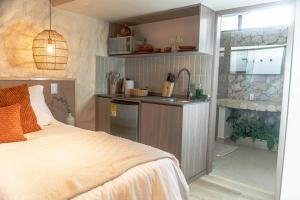 a bedroom with a bed and a kitchen with a sink at Casa Lezzet in Medellín
