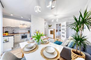 a kitchen and living room with a table and chairs at Dwupokojowy apartament Fordon w okolicy Onkologii in Bydgoszcz