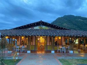 a house with a table and chairs in front of it at Cabaña Valle del Cocora in Salento