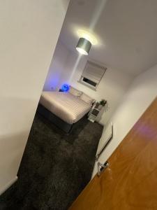 ein kleines Schlafzimmer mit einem Bett und einem blauen Licht in der Unterkunft Cozy Apartment in Edinburgh