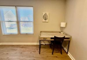 a desk with a chair in a room with two windows at Aksarben View Gem-Near UNO in Omaha