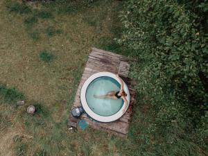 a person in a pool of water in a field at Łąka Gwiazd Jurty Czapla in Wałcz