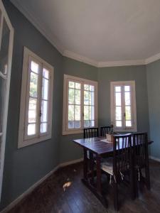 a dining room with a table and chairs and windows at Villa Aruanda in Petrópolis +8 photos
