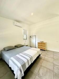 a bedroom with a bed in a white room at Tiny House Moorea Hinavai in Papetoai +7 photos