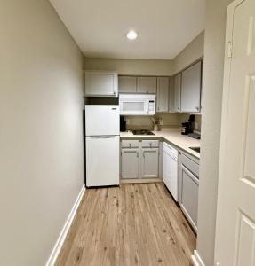 Una cocina con gabinetes blancos y un refrigerador blanco. en Cozy Aksarben Living-close to I-80 & WFH desk, en Omaha