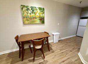mesa de comedor con 2 sillas y un cuadro en la pared en Cozy Aksarben Living-close to I-80 & WFH desk, en Omaha