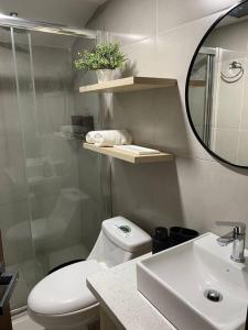 a bathroom with a toilet and a sink and a mirror at Apartamento con encanto cerca del centro de Cuenca in Cuenca