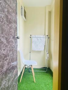 ein weißer Stuhl in einem Raum mit grünem Teppich in der Unterkunft Cozy place by seawind, Davao City Near davao airport SMX Sm lanang Sasa wharf, Dusit Thani, Grand regal hotel,Azuela cove and a lot more in Davao City