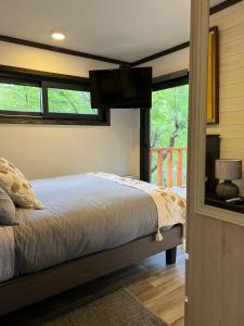 a bedroom with a bed and a balcony with a television at Tiny & Big House Suite Los Mallines de Malalcahuello in Malalcahuello
