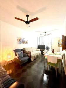 a living room with a couch and a ceiling fan at Apartamento 412B com varanda e vista in Santos