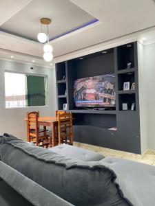 un salon avec un canapé et une télévision dans l'établissement Casa na praia no Guarujá, à Guarujá