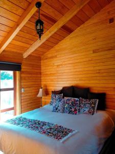 - une chambre avec un lit et un mur en bois dans l'établissement Conecta con la Naturaleza y Confort en Cabaña Villaluxe, à San Cristóbal de Las Casas