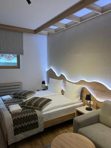a bedroom with a king sized bed and a couch at Privatni Studio Apartman RIO 028 u sklopu HOTEL VUČKO JAHORINA in Jahorina