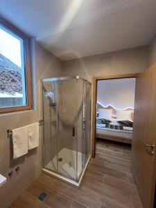 a bathroom with a glass shower and a bedroom at Privatni Studio Apartman RIO 028 u sklopu HOTEL VUČKO JAHORINA in Jahorina