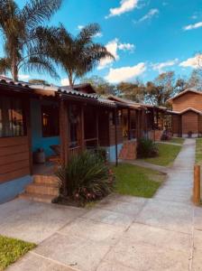 a house with palm trees in the background at Verde Mauá Chales in Visconde De Maua