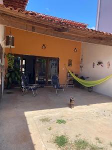 a cat sitting in front of a house with a hammock at Casa Luna - Réveillon in Japaratinga