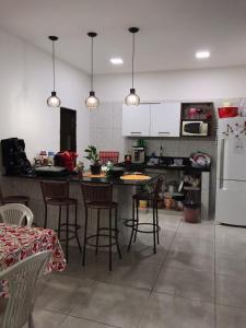 a kitchen with a table and chairs and a refrigerator at Casa Luna - Réveillon in Japaratinga