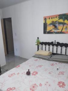 a bedroom with a bed with a painting on the wall at Casa Luna - Réveillon in Japaratinga