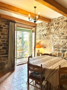a bedroom with a stone wall with a bed and chairs at Loustalet in Saint-Jean-de-la-Blaquière
