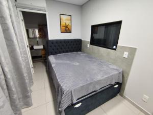 Zimmer mit einem Bett und einem Flachbild-TV in der Unterkunft Casa de praia - Bombinhas in Bombinhas