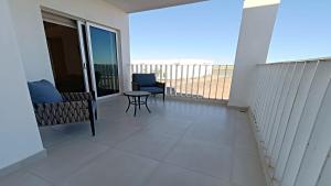 a balcony with a table and chairs and a view of the ocean at Costa Divina A2 by Kivoya in La Choya