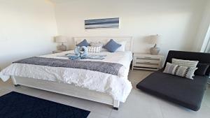 a bedroom with a large bed and a chair at Costa Divina A2 by Kivoya in La Choya