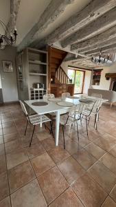 a dining room with a white table and chairs at LAOUEN - grande maison de campagne in Saint-Igneuc