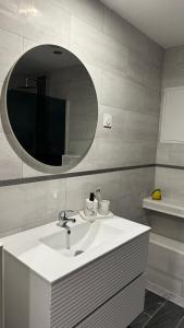 a bathroom with a white sink and a mirror at Lescapade in Luxeuil-les-Bains