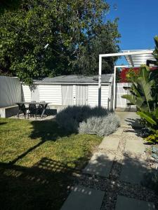 einen Hinterhof mit einem Picknicktisch und einem Zaun in der Unterkunft Luxe cottage in the heart of Sandy Bay in Sandy Bay