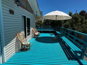 a deck with two chairs and an umbrella on a house at El Tabo Casa Consistorial in El Tabo