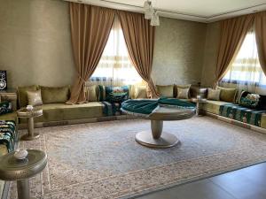 a living room with a couch and a table at charmante villa de luxe à Marrakech in Marrakesh