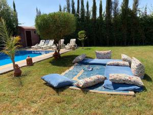 a group of pillows on the grass next to a pool at charmante villa de luxe à Marrakech in Marrakesh