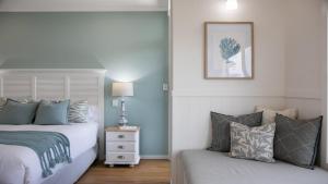 a bedroom with two beds and a couch at Amazing Views, Stunning Beaches and Beautiful Bushwalks in Hardys Bay
