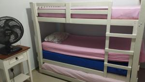 ポルト・ベロにあるCasa na Enseada Encantadaの二段ベッド1組(ファン付)、ナイトスタンドが備わります。