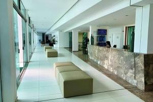 a lobby with couches and a bar in a building at Apartamento Luxor Tambaú in João Pessoa
