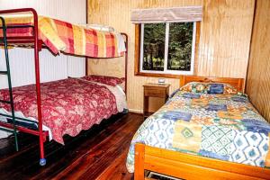 a bedroom with a bunk bed and a bed with a bed sqor at Cabaña La Granja de Tía Cone, Llanada Grande in Llanada Grande