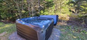 a hot tub sitting in the grass in a field at BLOOM - Luxe et Confort en forêt in Valcartier Station