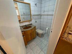 a bathroom with a toilet and a sink and a mirror at Dona Regina in Matinhos +22 photos