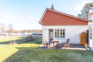 a small white house with a table and chairs at StrandLiebe am Strandbad in Malchow