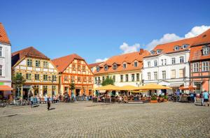 a town square with buildings and people walking around at MüritzLounge am Seeufer in Waren