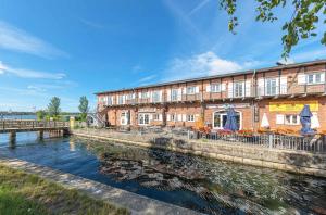 un edificio accanto a un corpo idrico di Kietz-Idylle - Gemütliche Ferienwohnung mit Balkon und Zugang zu Wellnessbereich a Waren