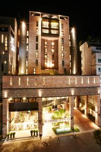 un grand bâtiment en briques avec des lumières devant lui dans l'établissement MD HOTEL Dongtan - Formerly Staz Hotel Dongtan, à Hwaseong